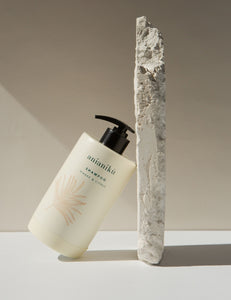 a ceramic shampoo bottle artfully positioned next to a slab of concrete